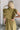Back view of the Meet Your Match Dress that features a green colored material, a collar neckline, a button-up front, a ruffle sleeve, side pockets, and a mini length.