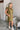 Frontal view of the Meet Your Match Dress that features a green colored material, a collar neckline, a button-up front, a ruffle sleeve, side pockets, and a mini length.