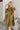 Frontal view of the Meet Your Match Dress that features a green colored material, a collar neckline, a button-up front, a ruffle sleeve, side pockets, and a mini length.
