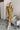 Frontal view of the Meet Your Match Dress that features a green colored material, a collar neckline, a button-up front, a ruffle sleeve, side pockets, and a mini length.
