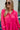 Frontal view of the Wide Open Spaces Mini Dress that features a hot pink material, a round neck with a ruffle trim, a 3/4 button-up front, a long sleeve, a tiered babydoll design, and a flowy fit.