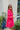 Side view of the Wide Open Spaces Mini Dress that features a hot pink material, a round neck with a ruffle trim, a 3/4 button-up front, a long sleeve, a tiered babydoll design, and a flowy fit.