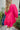 Back view of the Wide Open Spaces Mini Dress that features a hot pink material, a round neck with a ruffle trim, a 3/4 button-up front, a long sleeve, a tiered babydoll design, and a flowy fit.