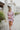 Frontal view of the Risk It All Dress that features a dusty pink silk material, a collar neck, a V surplice neckline, a long cuffed sleeve, a wrap front with a tie detail, and a mini length.