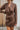 Frontal view of the Next Century Dress that features a brown tweed material, a navy gingham print, a lapel surplice neckline, a long sleeve, a wrap front with a tortoiseshell buckle, and a mini length.