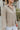 Frontal view of the Remember Me Top that features a taupe chiffon material, an ivory and yellow geometric print, a collar neckline, a button-up front, and a long sleeve.