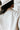 Close-up backl view of model wearing the Tell Me Everything Suede Shacket, which features a cream suede material, a collar neck, a button-up front, long cuffed sleeves, two front pockets, and a curved bottom hem