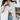 Front view of model wearing the Tell Me Everything Suede Shacket, which features a cream suede material, a collar neck, a button-up front, long cuffed sleeves, two front pockets, and a curved bottom hem. Shacket is unbuttoned over white brami