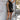Front view of model wearing The Midnight Magic Feather Dress features black fabric, a mock neckline, a sleeveless a-line silhouette, and a feather-trimmed hemline.