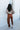 Full body back view of model wearing Running Up That Hill Joggers features a brown colored nylon material, a high-rise fit, a thick elastic waist with an adjustable tie, side pockets, and a jogger fit.