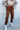 Front view of model wearing Running Up That Hill Joggers features a brown colored nylon material, a high-rise fit, a thick elastic waist with an adjustable tie, side pockets, and a jogger fit.