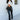 Full body front view of 5'8 model wearing the Next Level Straight Leg Pants features a black faux-leather material, a high-rise fit, a clasp and zipper front closure, belt loops, two front pockets, a middle seam down the legs, and a straight leg fit