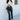 Full body front view of 5'8 model wearing the Next Level Straight Leg Pants features a black faux-leather material, a high-rise fit, a clasp and zipper front closure, belt loops, two front pockets, a middle seam down the legs, and a straight leg fit