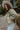 Side view of model wearing the Good Morning Teddy Jacket in Sage, that has light green sherpa fabric with cream corduroy accents, a zip-up front, a front zipper pocket, and long sleeves. Worn unzipped over white top.