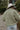 Back view of model wearing the Good Morning Teddy Jacket in Sage, that has light green sherpa fabric with cream corduroy accents, a zip-up front, a front zipper pocket, and long sleeves. Worn unzipped over white top.