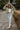 Full body front view of model wearing the Good Morning Teddy Jacket in Sage, that has light green sherpa fabric with cream corduroy accents, a zip-up front, a front zipper pocket, and long sleeves. Worn unzipped over white top.
