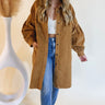 Front view of model wearing the All About You Corduroy Shacket that has camel corduroy fabric, two front chest pockets , a button-up front, a collar, two side pockets, a midi-length hem and long sleeves. Worn unbuttoned.
