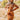 Front view of model wearing the Sedona Sands Dress, that has stretchy knit fabric with a brown, orange, rust, and pink swirl print, long sleeves, a square neckline, and a pink lining
