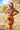 Front view of model wearing the Sedona Sands Dress, that has stretchy knit fabric with a brown, orange, rust, and pink swirl print, long sleeves, a square neckline, and a pink lining