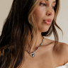 Close front view of female model wearing the Isla Silver Heart Chain Necklace.