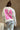 Back view of model wearing the Babe Pink & Cream Long Sleeve Sweatshirt which features cream knit fabric, thick hem, round neckline and long sleeves with cuffs. Graphic says "BABE" in pink with a mini heart design and "BABE" in pink letterman on the back.