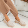 Right front angle view of the female model wearing the Elias Flat in Dune Suede which features tan suede upper fabric, monochrome rubber sole, slide-on style and slight square toe design.