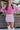 Front view of model wearing the Shine On Sequin Skirt in Pink, which features light pink fabric with a sequined overlay, ruching on the front, and an elastic waist.