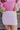 Close front view of model wearing the Shine On Sequin Skirt in Pink, which features light pink fabric with a sequined overlay, ruching on the front, and an elastic waist.