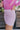 Close side view of model wearing the Shine On Sequin Skirt in Pink, which features light pink fabric with a sequined overlay, ruching on the front, and an elastic waist.