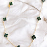Aerial image of the Emerald Dreams Necklace, that features a gold chain with emerald green rhinestone flowers.