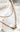 Close-up view of the Stay Golden Necklace, that features double gold chains with a clear rectangular stone.