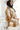 Side view of model wearing the Warm Wishes Plaid Shacket that has brown, black and cream plaid with a cream faux-fur lining, a button-up front, a collar, two front pocket, and long sleeves. 