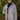 Front view of model wearing the On The Road Plaid Shacket that has taupe, cream and black plaid, a button-up front, a collar, two front chest pockets, and long sleeves. Worn unbuttoned over black top.