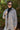Front view of model wearing the On The Road Plaid Shacket that has taupe, cream and black plaid, a button-up front, a collar, two front chest pockets, and long sleeves. Worn unbuttoned over black top.