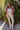 Full body front view of model wearing the Destination Trip Teddy Shacket in Pink that has dusty pink teddy fabric, a snap-up front, a collar, chest pockets, and long sleeves. Worn unbuttoned over white top.