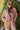 Front view of model wearing the Destination Trip Teddy Shacket in Pink that has dusty pink teddy fabric, a snap-up front, a collar, chest pockets, and long sleeves. Worn unbuttoned over white top.