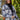 Front view of model wearing the Home For The Holidays Plaid Shacket that has black, white and grey plaid, front chest pockets, a button-up front, a collar, and long sleeves. Worn unbuttoned over black top.