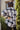 Back view of model wearing the Home For The Holidays Plaid Shacket that has black, white and grey plaid, front chest pockets, a button-up front, a collar, and long sleeves. Worn unbuttoned over black top.