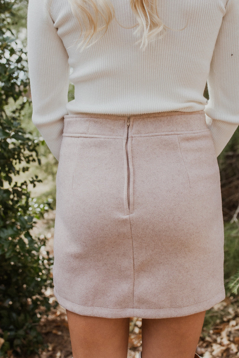 Back view of The All American Skirt In Oatmeal features oatmeal knit fabric, two front pockets, mini length, and back zipper closure.