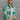Front view of model wearing the Lucky Day Plaid Shacket that has green, grey, brown and cream plaid, chest pockets, lower pockets, a button up front with a collar, slits, and long sleeves.
