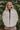 Front view of The Floral Dreams Jacket features cream coloring fabric, flower stitched pattern, two front buttoned chest pockets, cream button up with a collared neckline, two side pockets, and long sleeves with buttoned cuffs.