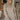 Front view of model wearing the On The Go Sweater Dress In Tan that has tan, white and grey knit fabric, a round neckline,  long sleeves, ribbed trim, and a mini-length hem
