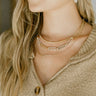 Front view of model wearing the Cheerful Spirits Necklace which features triple chain link with large chain links in clear stones.