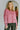 Front view of model wearing the Give Me A Reason Top, that features dark pink knit fabric, a henley neckline with gold buttons closures, side slits, dropped shoulders, and long balloon sleeves.