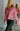 Front view of model wearing the Give Me A Reason Top, that features dark pink knit fabric, a henley neckline with gold buttons closures, side slits, dropped shoulders, and long balloon sleeves.