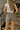 Back view of model wearing the Better This Way Houndstooth Shorts that have brown and cream fabric with a houndstooth pattern, two front pockets, a front zipper and hook closure, a full lining, belt loops, and two back pockets