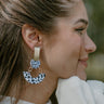 Close side view of model wearing the On The Spot Earrings that feature gold rectangles on post backs with white and black spotted circles and half arches.