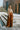 Full body view of model wearing the Need More Time Satin Pants which features copper silk fabric, two front pockets, a zip and hook closure, a half elastic waistband, and wide legs.