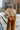 Back view of model wearing the Need More Time Satin Pants which features copper silk fabric, two front pockets, a zip and hook closure, a half elastic waistband, and wide legs.