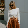 Front view of model wearing the Be Your Best Top which features cream textured fabric, round neckline, cropped waist, front only lining, sheer back, open key hole with drawstring and long sleeves.